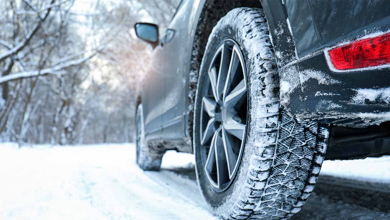Ein Auto auf einer verschneiten Straße, Nahaufnahme der Reifen